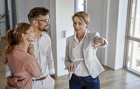 Immobilienmaklerin mit Kunden