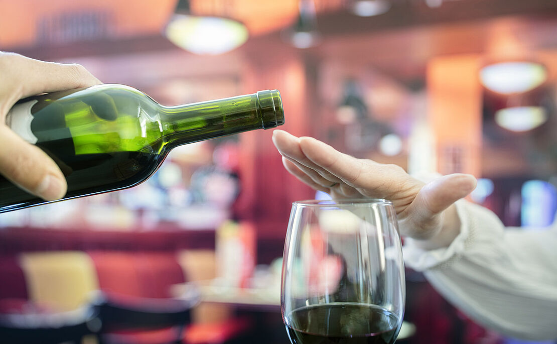 Hand über dem Glas, damit kein Wein eingeschenkt wird 