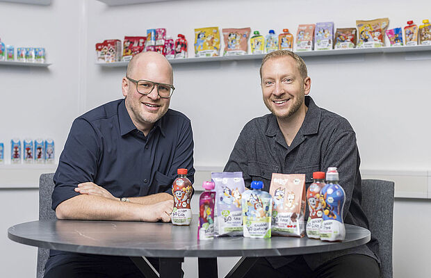 Christian Eibl und Reinhold Hinterplattner bei Tisch sitzend, vor ihnen einige ihrer Produkte