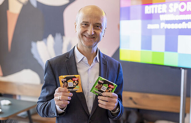 Foto von Wolfgang Stöhr mit den neuen Innovationen Vegan Tropical Coconut und Protein-Schokolade im 75-Gramm-Format