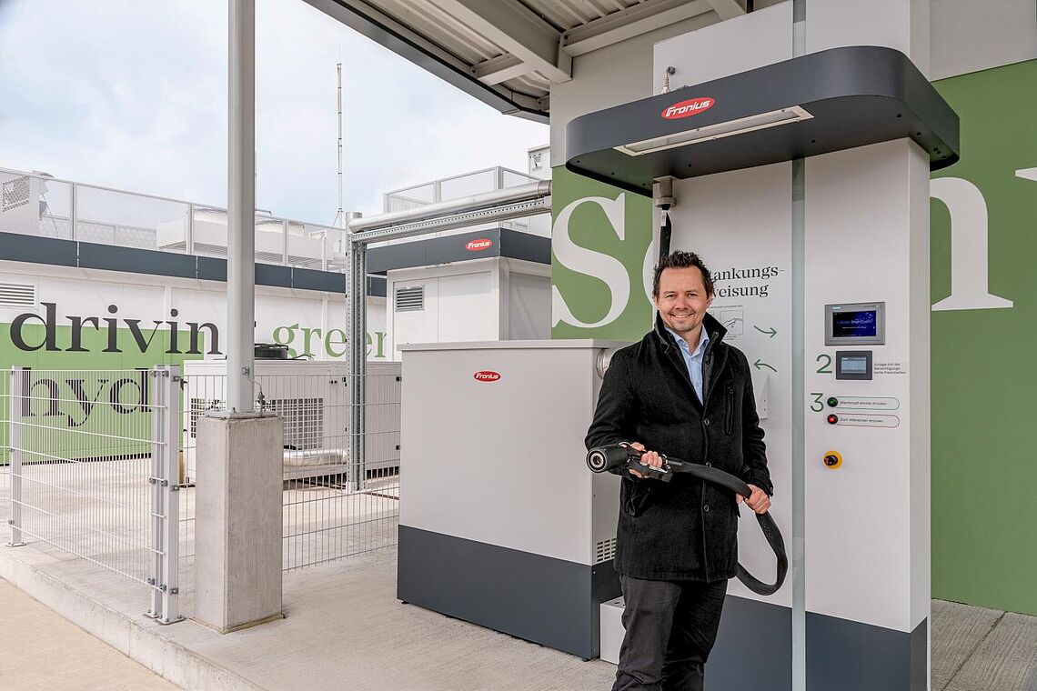 Mann beim auftanken von Wasserstoffauto