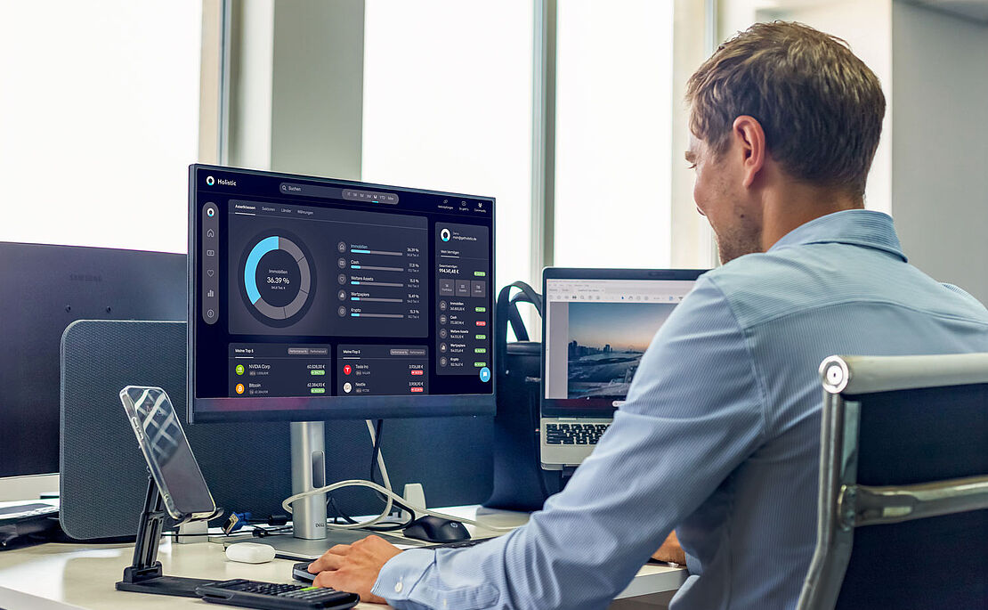 Mann von seitlich hinten, der vor seinem PC sitzt