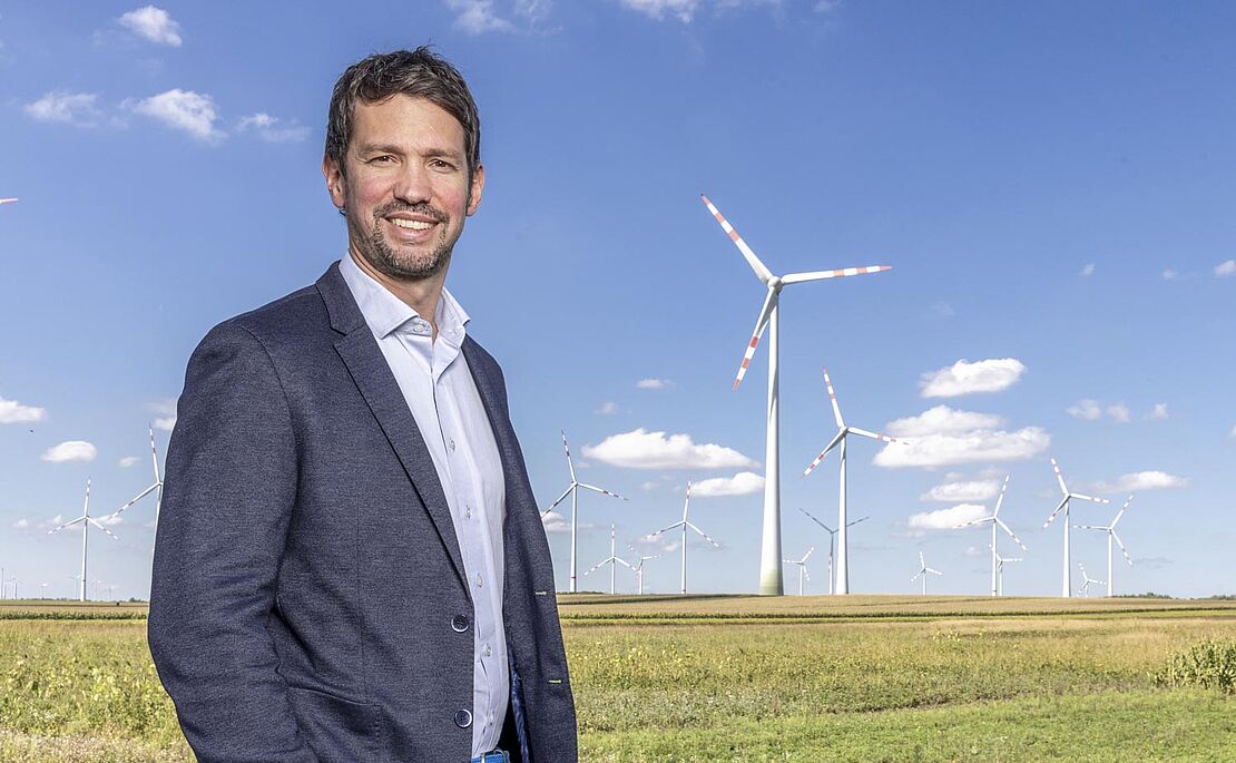 Lukas Püspök vor Landschaft mit Windrädern