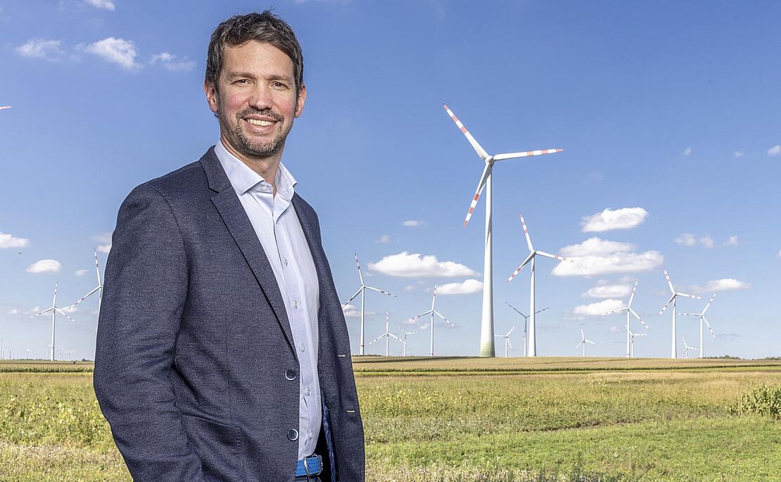 Lukas Püspök vor Landschaft mit Windrädern