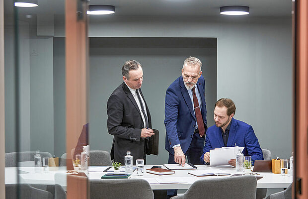 Drei Männer im Anzug im Gespräch