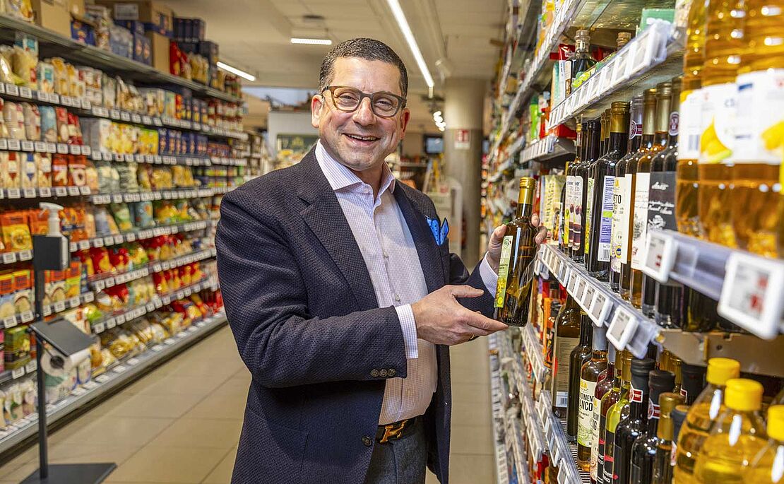 Marcel Haraszti vor einem Billa Regal mit Flasche Öl in der Hand