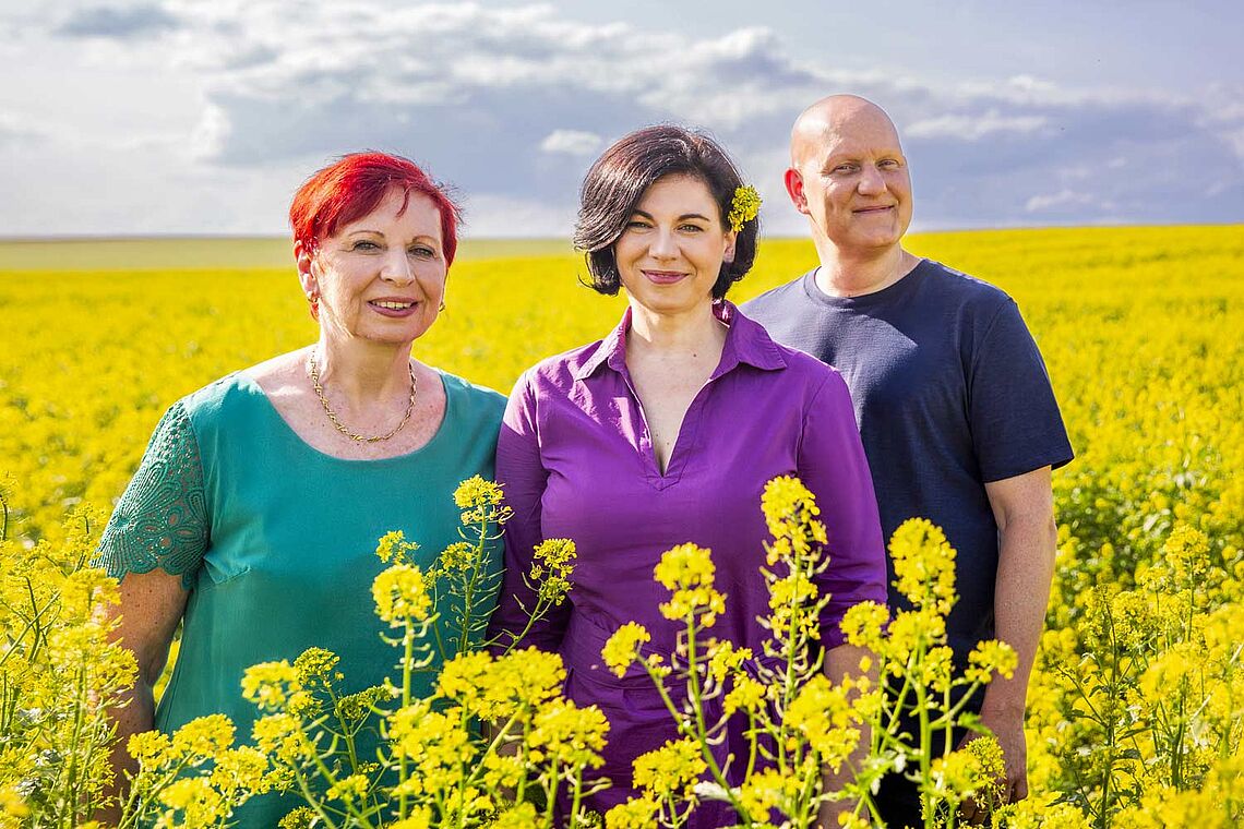 Liselotte Puta und Katrin und Stephan Segel in einem gelb blühenden Feld